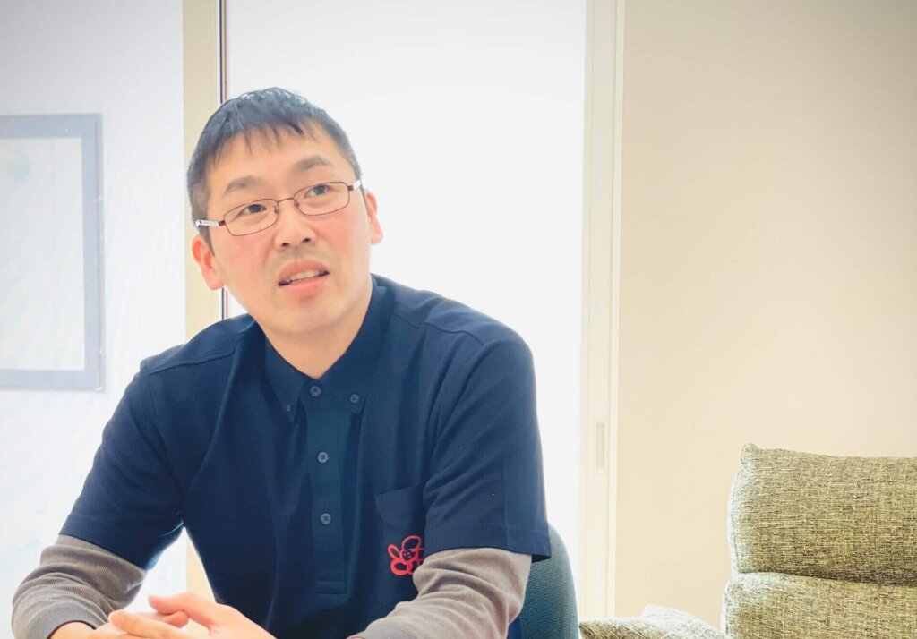 机に向かって座る男性