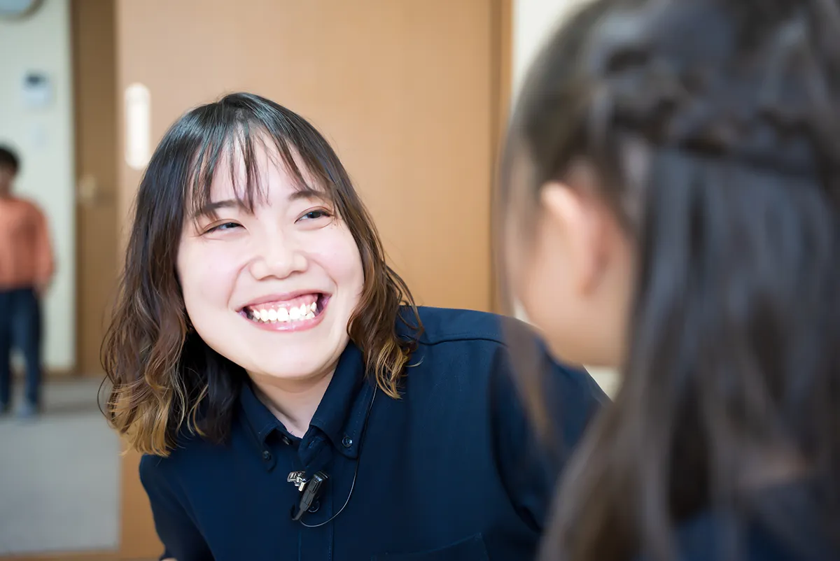 子どもに目線を合わせ、笑顔で話しかけるぽっけりんくのスタッフ