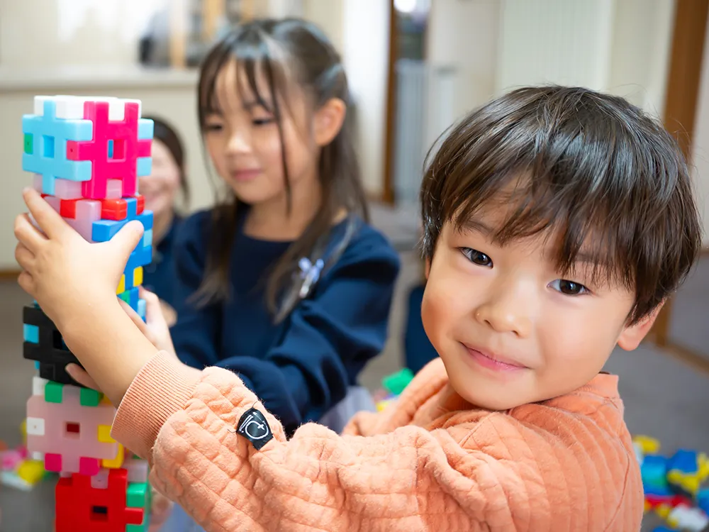 ブロック遊びの合間に笑顔を見せる男の子
